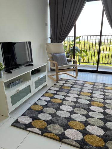 a living room with a tv and a chair and a rug at PadiViu Family Suite at Imperio Professional Suite, Alor Setar in Alor Setar