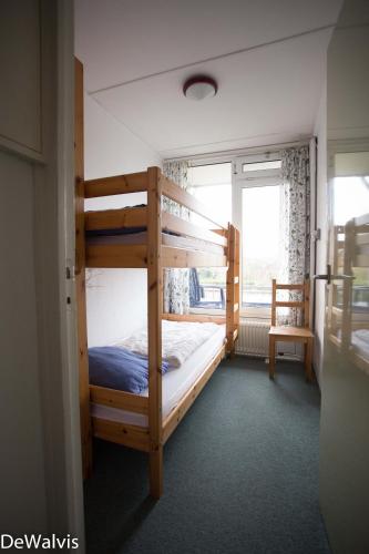 a bedroom with two bunk beds and a window at Appartement Walvis nr. 16B in Vrouwenpolder