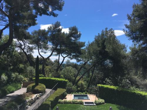 a garden with a pool and trees in the background at Hotel****Spa & Restaurant Cantemerle in Vence