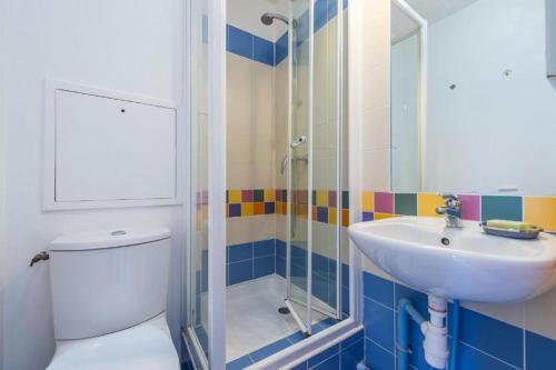 a bathroom with a toilet and a sink and a shower at Rainbow Duplex N°1 Disney in Serris
