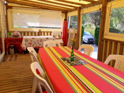 Cette chambre comprend une table et des chaises rouge et jaune. dans l'établissement Bungalow charmant à Saint-Julien-en-Born avec piscine partagée, à Saint-Julien-en-Born
