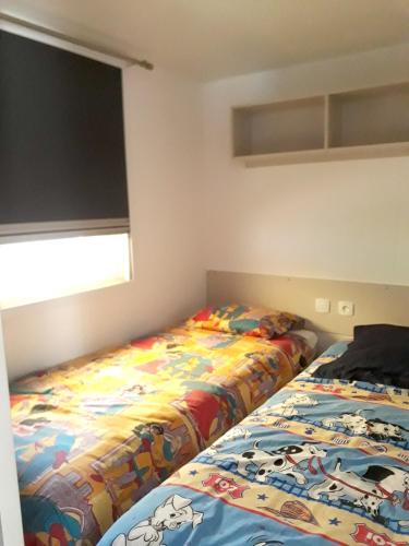 deux lits côte à côte dans une chambre dans l'établissement Bungalow charmant à Saint-Julien-en-Born avec piscine partagée, à Saint-Julien-en-Born