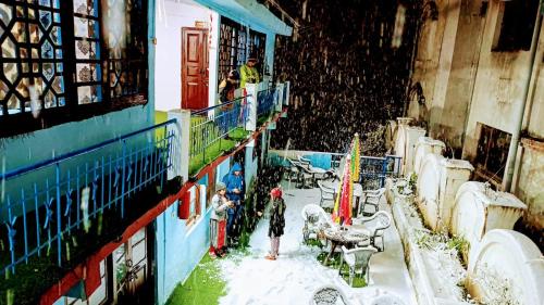 a group of people standing in the snow in a building at The HappyTel in Mussoorie
