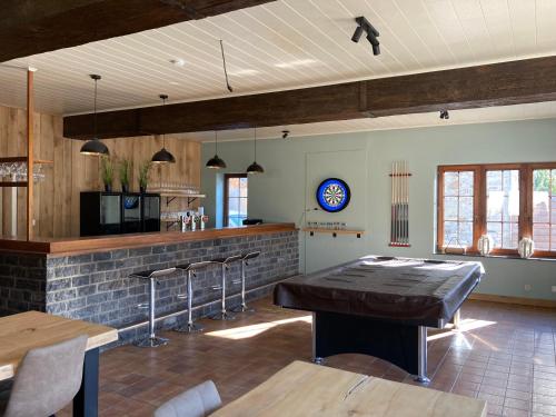 a kitchen with a table and a bar with stools at Villa Dhoris in Ferrières