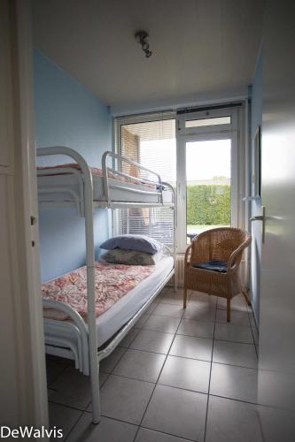 a bedroom with two bunk beds and a window at Appartement Walvis nr. 24 in Vrouwenpolder