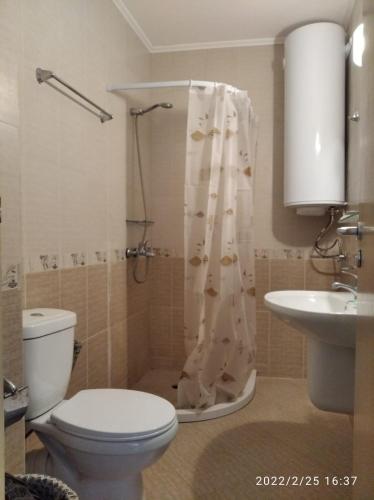 a bathroom with a toilet and a sink and a shower at Great Choice Apartment in Chernomorets