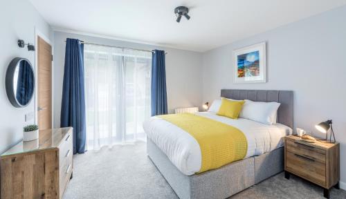 a bedroom with a bed and a large window at High Range Holiday Apartments in Aviemore