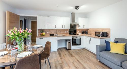 a kitchen and living room with a table and a couch at High Range Holiday Apartments in Aviemore