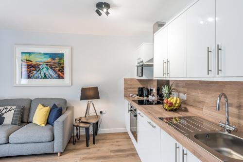a kitchen with a couch and a sink in a room at High Range Holiday Apartments in Aviemore