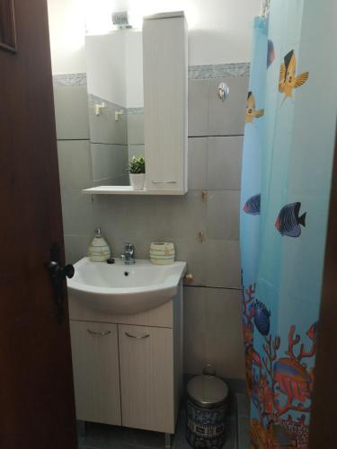 a bathroom with a sink and a mirror and a shower curtain at Παραθαλασσιο στουντιο Μιχαλιας Sea view studio Michalias Νουμερο 8 in Agia Marina Aegina