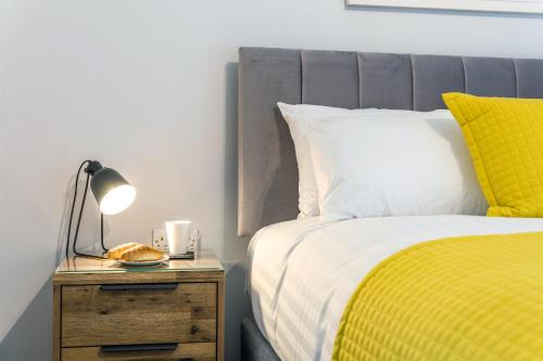 a bedroom with a bed and a lamp on a night stand at High Range Holiday Apartments in Aviemore