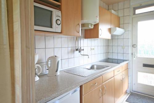 uma cozinha com um lavatório e um micro-ondas em Appartement Walvis nr. 9E em Vrouwenpolder