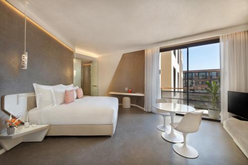 a bedroom with a white bed and a large window at Pestana CR7 Marrakech in Marrakech