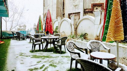 a patio with tables and chairs covered in snow at The HappyTel in Mussoorie