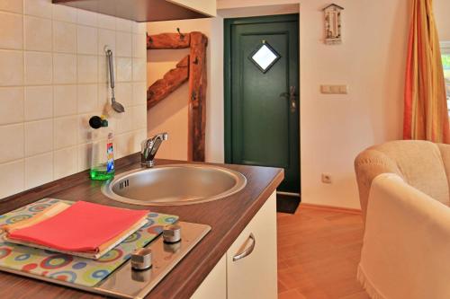 a small bathroom with a sink and a green door at Fischerkate Freest in Freest