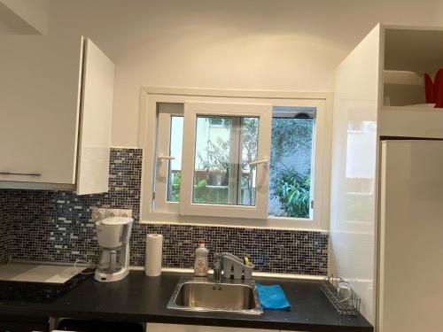 uma cozinha com um lavatório e uma janela em George House em Atenas