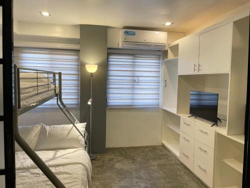 CRIB 252 Subic Bay في سوبيك: غرفة نوم صغيرة مع سرير بطابقين وتلفزيون