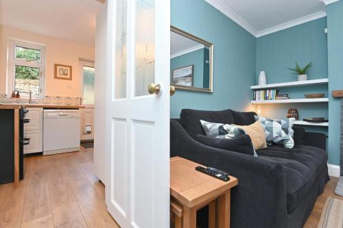 a blue living room with a couch and a table at Derwent Valley View in Whatstandwell