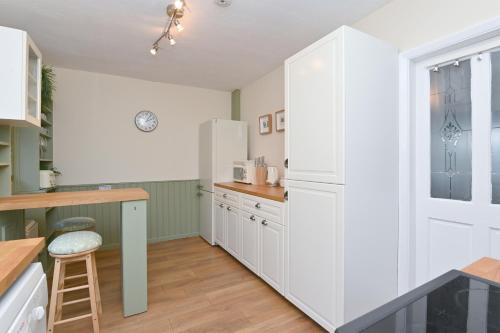 a kitchen with white cabinets and a white refrigerator at Derwent Valley View in Whatstandwell