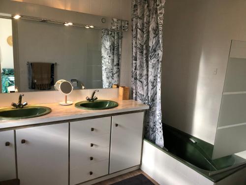 une salle de bain avec deux lavabos et un grand miroir dans l'établissement La Petite Noix, à Sarlat-la-Canéda