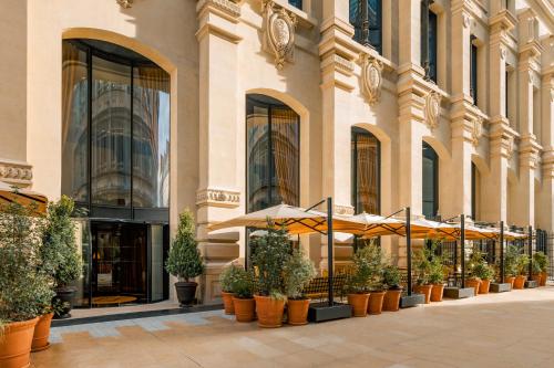 a building with umbrellas and potted plants in front of it at Hôtel Madame Rêve in Paris