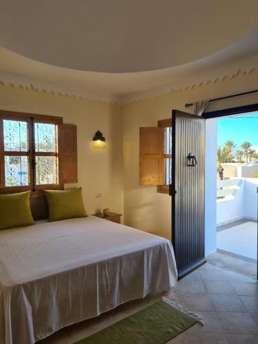 a bedroom with a large bed and a balcony at Villa Louiza in Mezraya