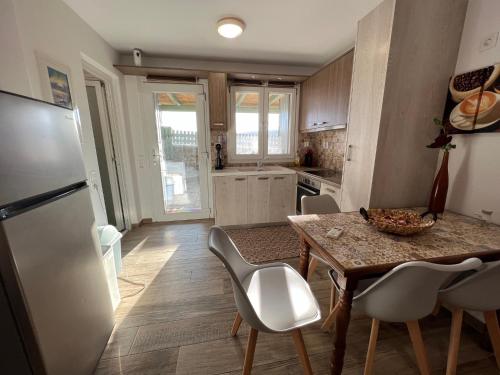uma cozinha com uma mesa e cadeiras e um frigorífico em Voula's Cozy Studio in Ano Mera Mykonos em Ano Mera