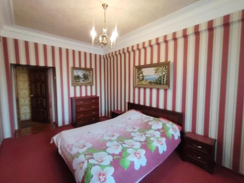 1 dormitorio con cama y paredes de rayas rosas y blancas en Просторная "сталинка" на проспекте Ленина, 47 en Dzerzhinsk