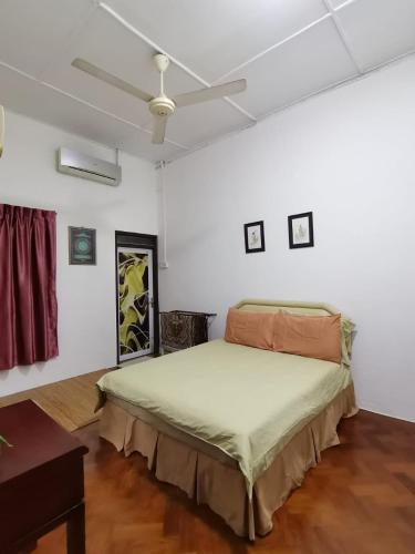 een slaapkamer met een bed en een plafondventilator bij TS GUEST HOUSE in Kuantan