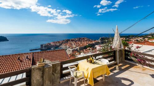 a table and chairs on a balcony with a view of the ocean at Guesthouse Home Sweet Home in Dubrovnik