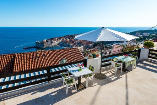 a patio with an umbrella and a table and chairs at Guesthouse Home Sweet Home in Dubrovnik