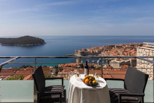 una mesa con una botella de vino y un bol de fruta en Guesthouse Home Sweet Home, en Dubrovnik