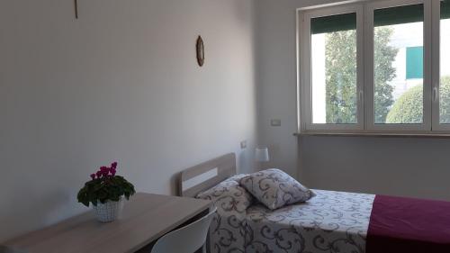 een slaapkamer met een bed, een bureau en een raam bij Trullo dell'Immacolata - Casa vacanze gestita da suore in Selva di Fasano