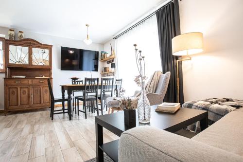 ein Wohnzimmer mit einem Sofa und einem Tisch in der Unterkunft Apartament Słoneczne Tatry Droga na bystre 5b in Zakopane