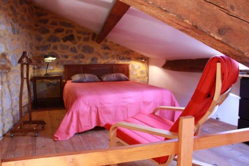 a bedroom with a pink bed and a chair at LE PETIT CLOS in Fontjoncouse