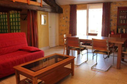 uma sala de estar com um sofá vermelho e uma mesa em LE PETIT CLOS em Fontjoncouse