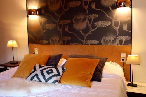 a bedroom with a bed with pillows and a wallpaper at LE PETIT CLOS in Fontjoncouse