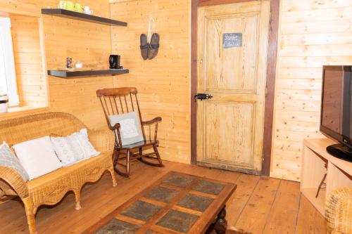 a living room with a couch and a chair and a television at La Fée Maison in Châtel-sur-Moselle
