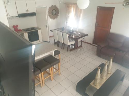 a kitchen and living room with a table and chairs at 5 bedroom home in Langebaan, located close to Club Mykonos and Laguna Mall in Langebaan