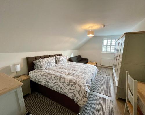 a bedroom with a bed and a dresser at Cotswold Hare in Cirencester