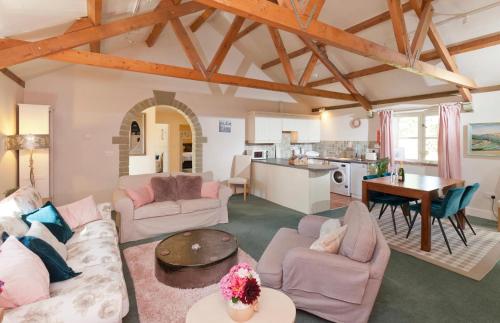 uma sala de estar com dois sofás e uma mesa em Spacious Swallow Cottage em Tisbury