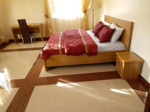 a bedroom with a bed with a red comforter at Amoni Apartments in Port Harcourt