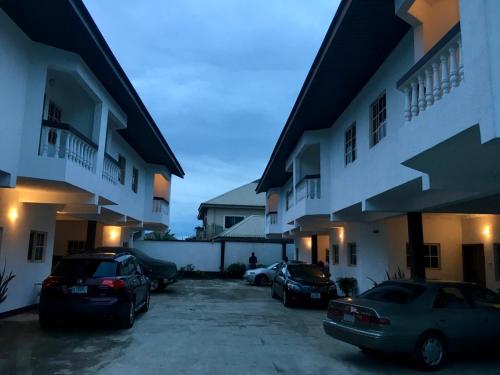 two cars parked in a parking lot in front of a building at Amoni Apartments in Port Harcourt