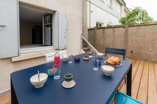 ル・ブスカにあるFurnished Townhouse Ideally Located With 4 Bedrooms Large Terrace & Gardenのバルコニーに青いテーブルと食べ物