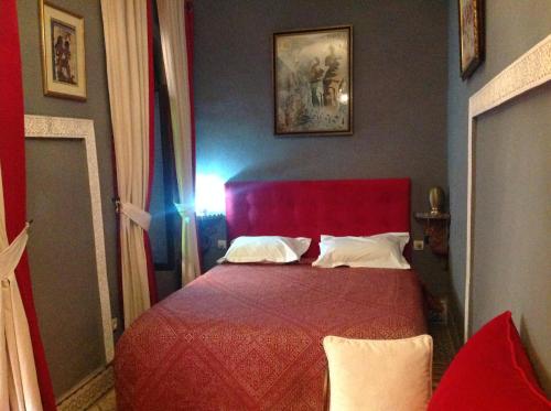 a bedroom with a red bed with a red head board at Riad Syba in Marrakech