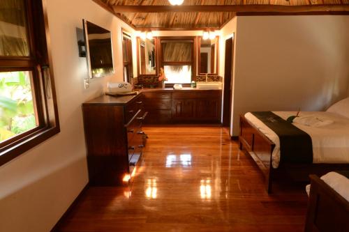a bedroom with a bed and a desk and a kitchen at El Ben Cabañas in Caye Caulker