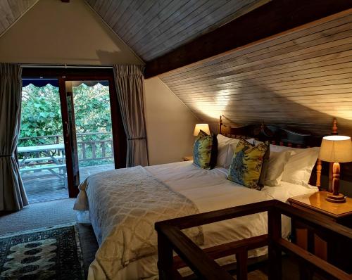 a bedroom with a large bed with a wooden ceiling at Tsitsikamma Gardens Self-Catering Cottages - Cottage #2 in Sanddrif