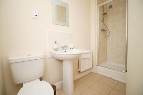 a bathroom with a toilet and a sink and a shower at Alicia's Way by Tŷ SA in Newport