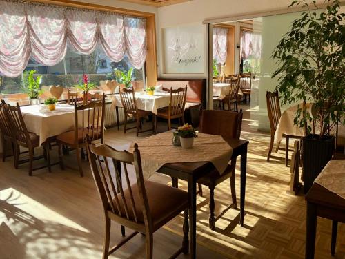 a restaurant with tables and chairs and a large window at Landhotel Kunzental in Zorge