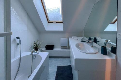 a white bathroom with a sink and a bath tub at L'Alp'Oz in Oz
